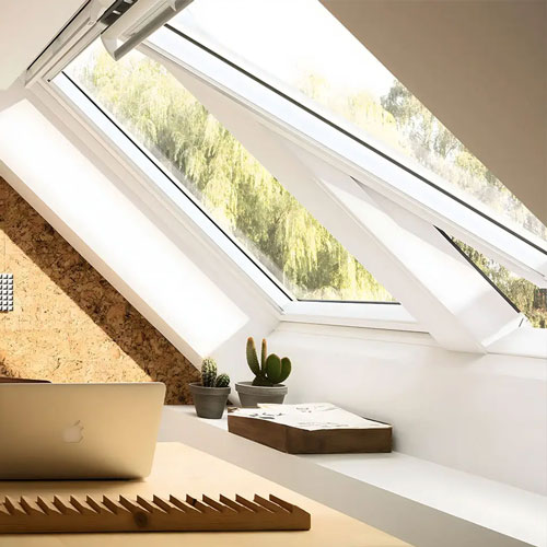 Fenêtre de toit Velux installée dans un comble aménagé lumineux
